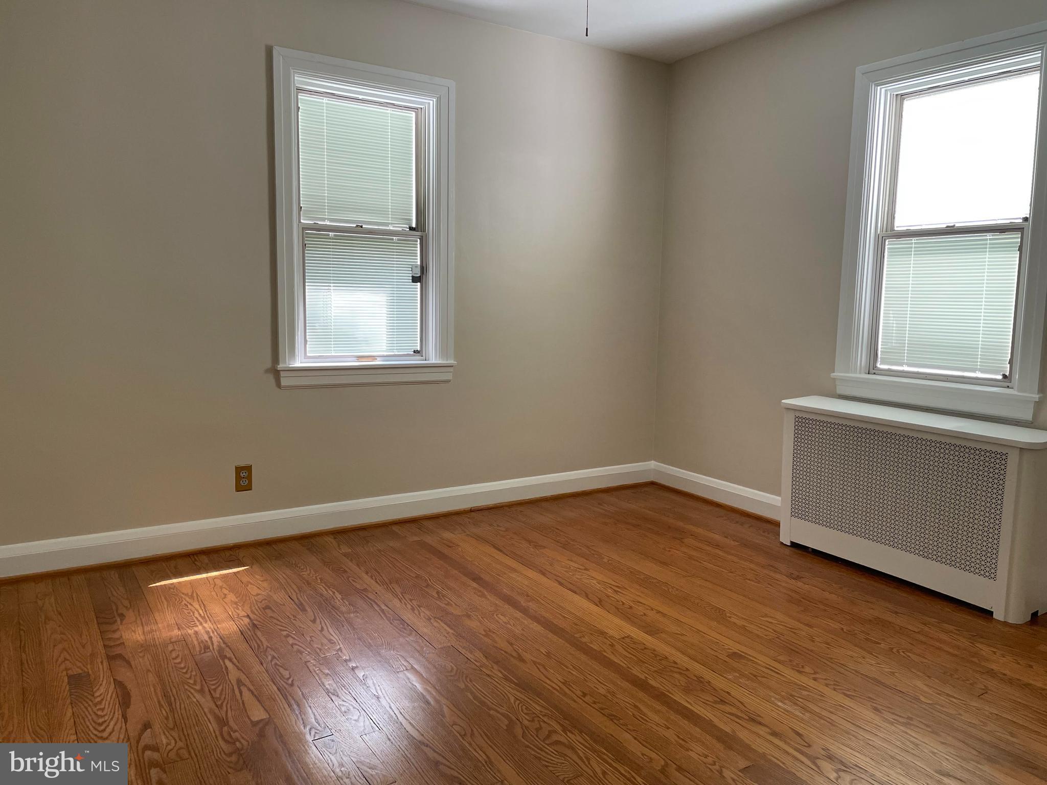 922 Overbrook Road Baltimore, MD 21239 - Photo 7 of 15 an empty room with wooden floor and windows