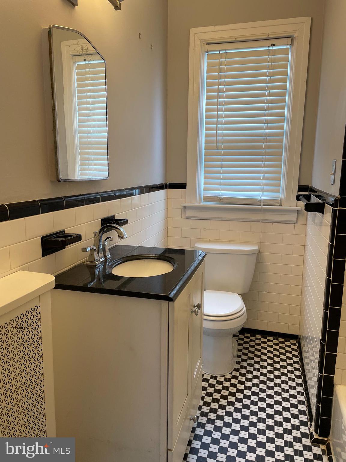 922 Overbrook Road Baltimore, MD 21239 - Photo 9 of 15 a bathroom with a sink a toilet and a mirror