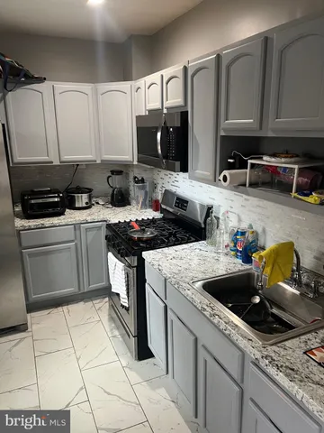 a kitchen with stainless steel appliances wooden cabinets and a refrigerator