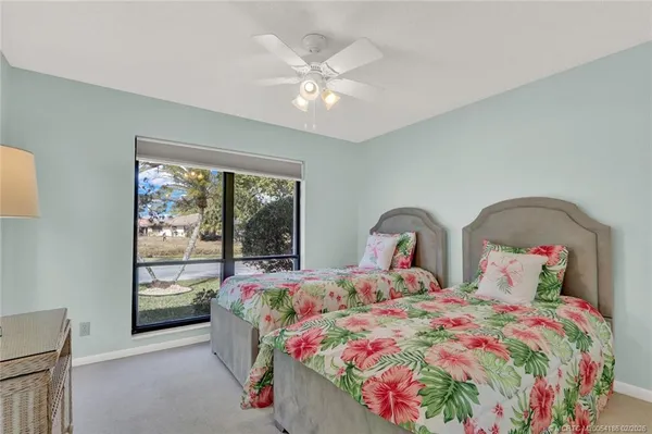 a bedroom with two beds and window