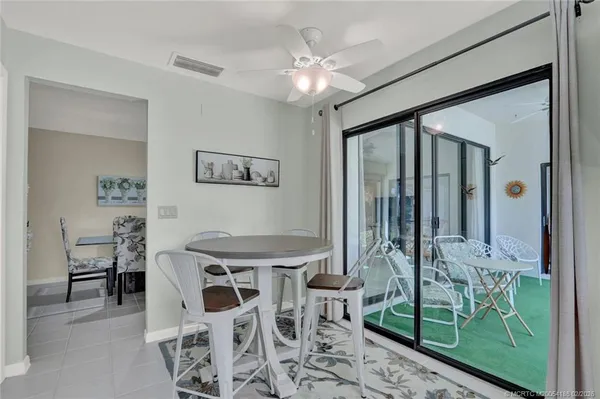 a view of a dining room with furniture one side kitchen view and a chandelier