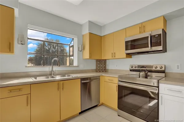 a kitchen with stainless steel appliances granite countertop a sink stove and microwave