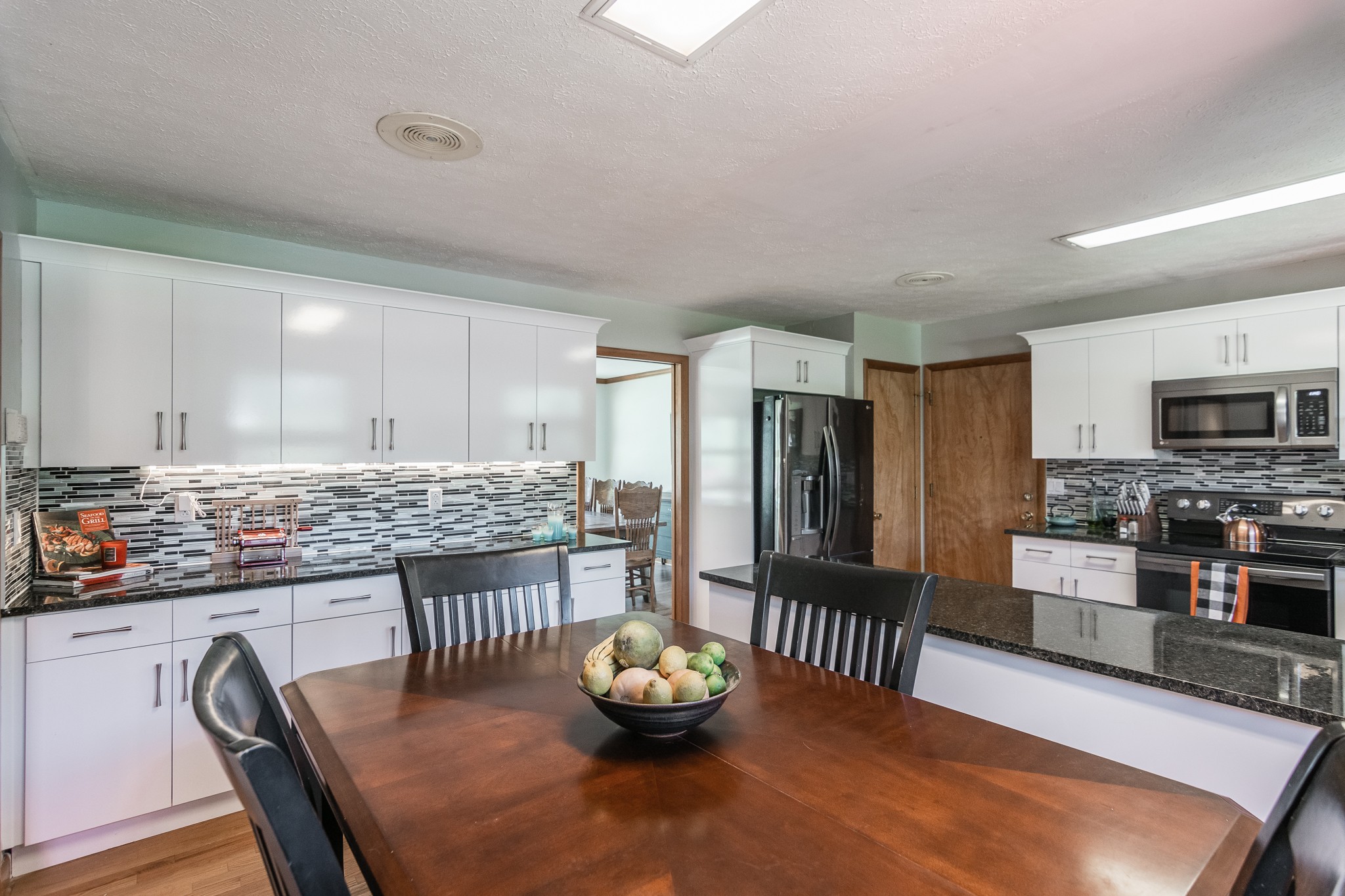 705 Ronnie Road Madison, TN 37115 - Photo 9 of 50 a kitchen with stainless steel appliances granite countertop a stove top oven a sink dishwasher and a refrigerator with wooden floor