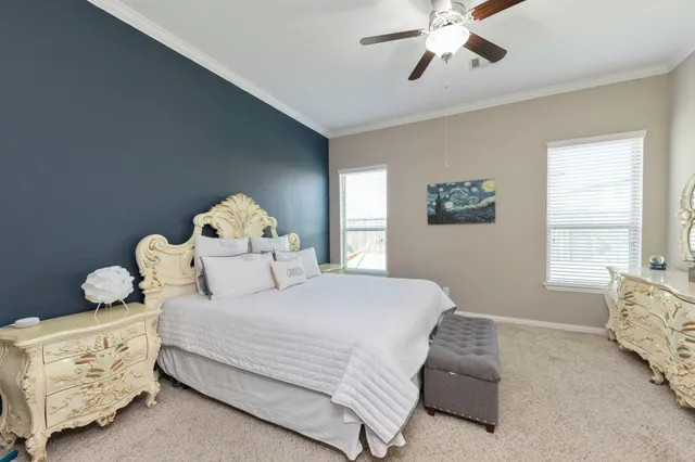 a bedroom with a bed and a chandelier fan
