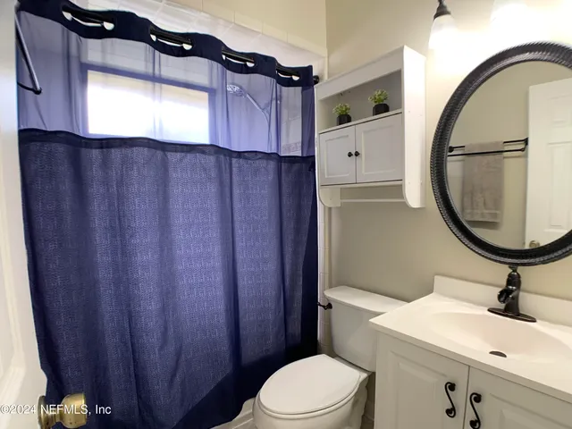 a bathroom with a sink a toilet and a mirror