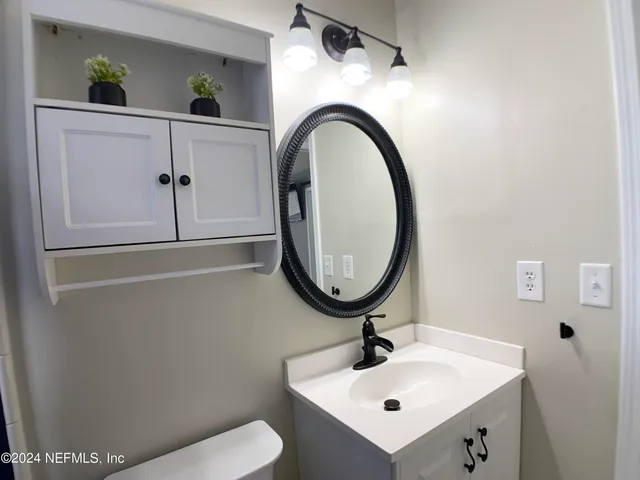 a bathroom with a sink a mirror and a toilet
