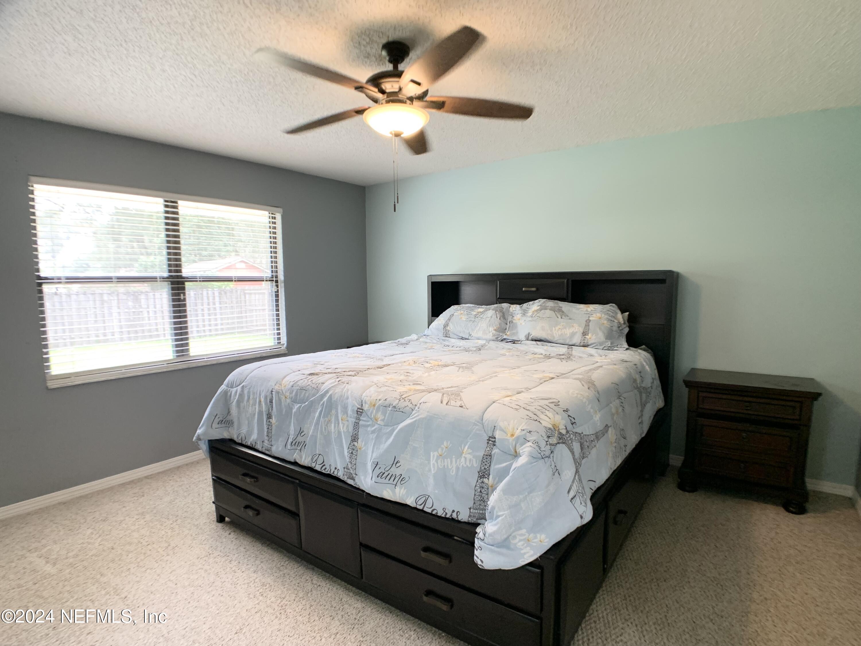 3149 Lakeside Villa Road Orange Park, FL 32073 - Photo 24 of 42 a bed sitting in a bedroom next to a window