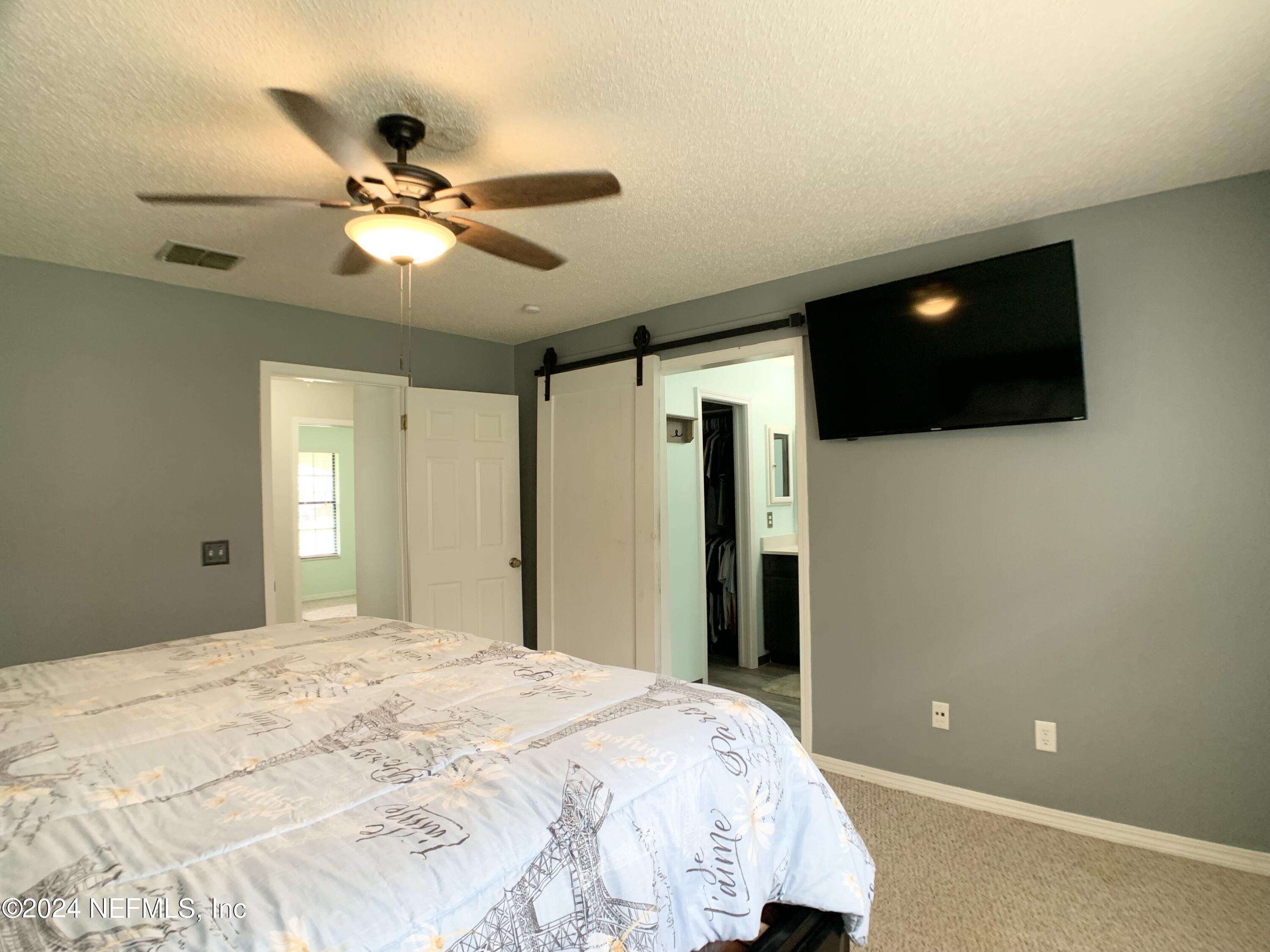 3149 Lakeside Villa Road Orange Park, FL 32073 - Photo 25 of 42 a bedroom with a bed and a flat screen tv