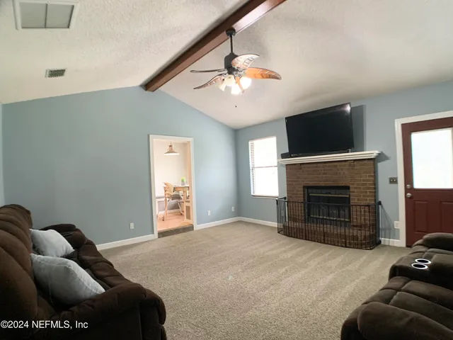 a living room with furniture a flat screen tv and a fireplace