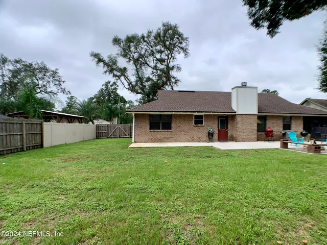 a front view of a house with a garden and trees