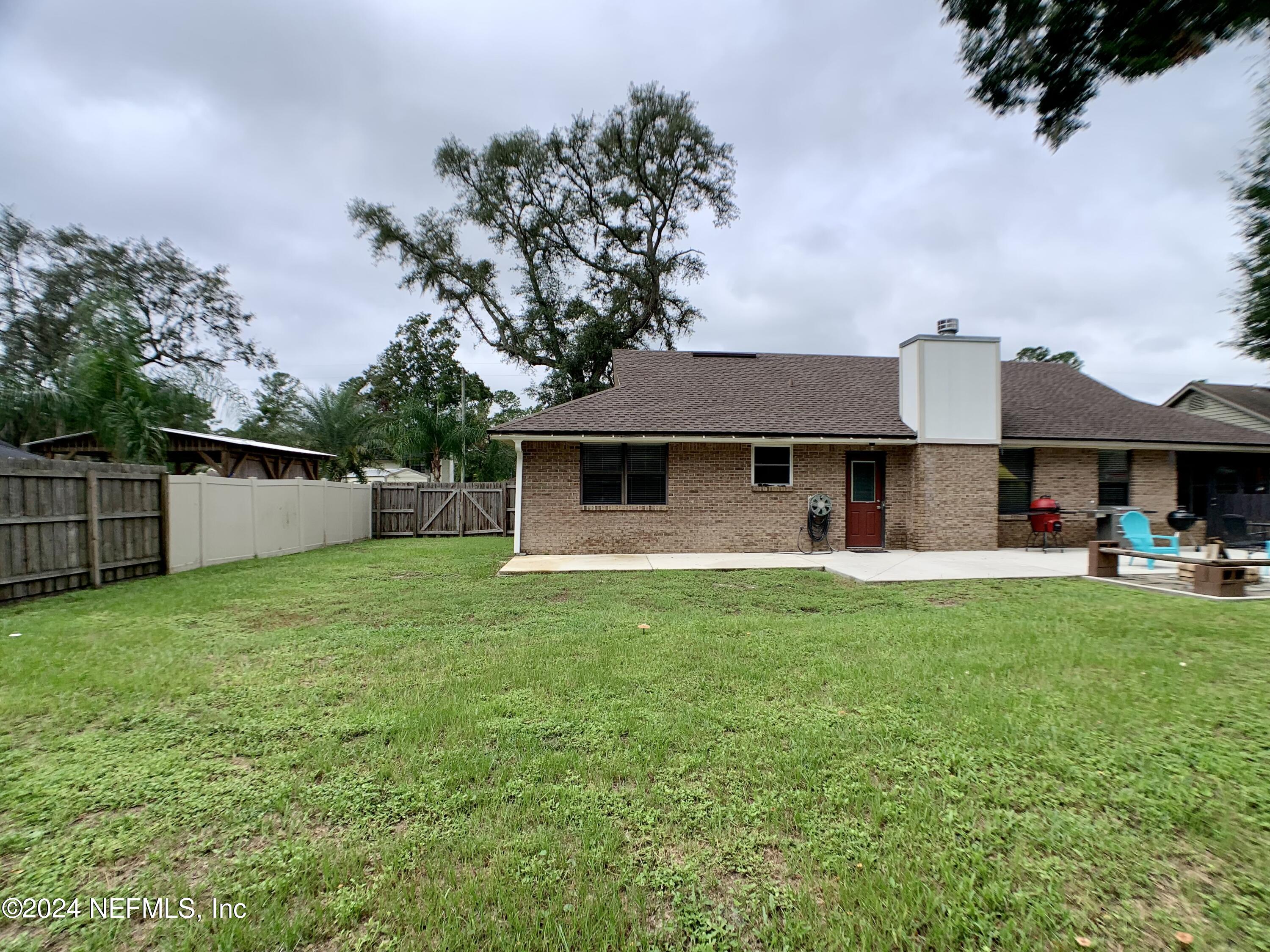 3149 Lakeside Villa Road Orange Park, FL 32073 - Photo 40 of 42 a front view of a house with a garden and trees