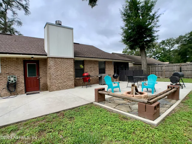 a view of a house with backyard and sitting area