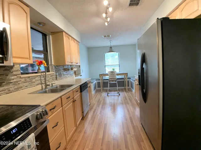 a kitchen with a sink appliances and cabinets