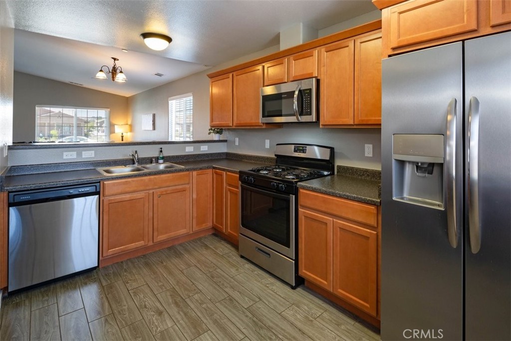 664 Chick Lane San Miguel, CA 93451 - Photo 3 of 14 a kitchen with stainless steel appliances granite countertop a stove a sink dishwasher a refrigerator and a microwave oven with wooden floor