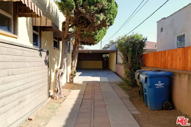 a view of a house with a barbeque and wooden stairs