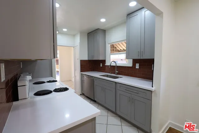 a kitchen with a sink a counter and a refrigerator