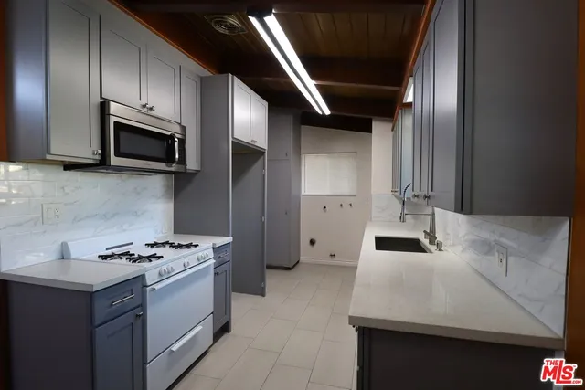 a kitchen with granite countertop stainless steel appliances and cabinets