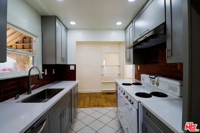 a kitchen that has a sink and a stove in it