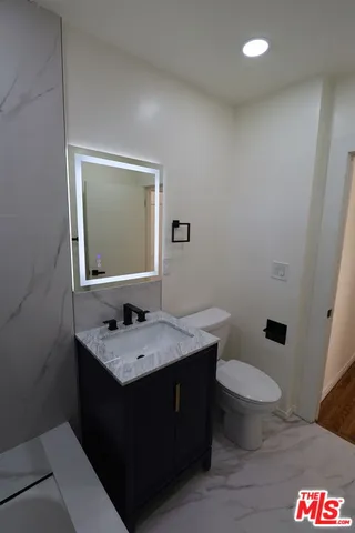 a bathroom with a granite countertop sink and a mirror