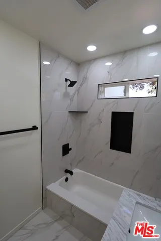 a bathroom with a tub and a shower