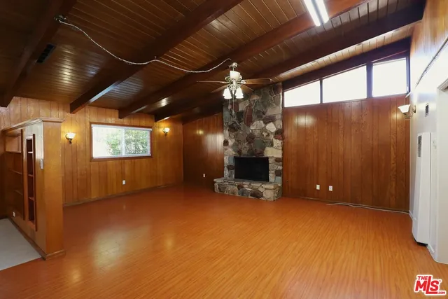 a view of an empty room with a fireplace and a chandelier