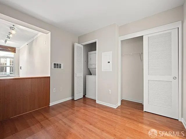 a view of empty room with wooden floor