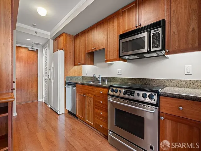 a kitchen with stainless steel appliances granite countertop a stove microwave and refrigerator