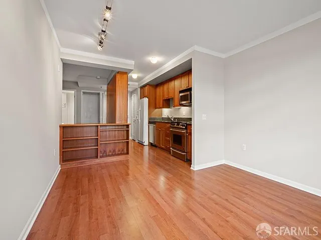 a living room with stainless steel appliances wooden floor and floors