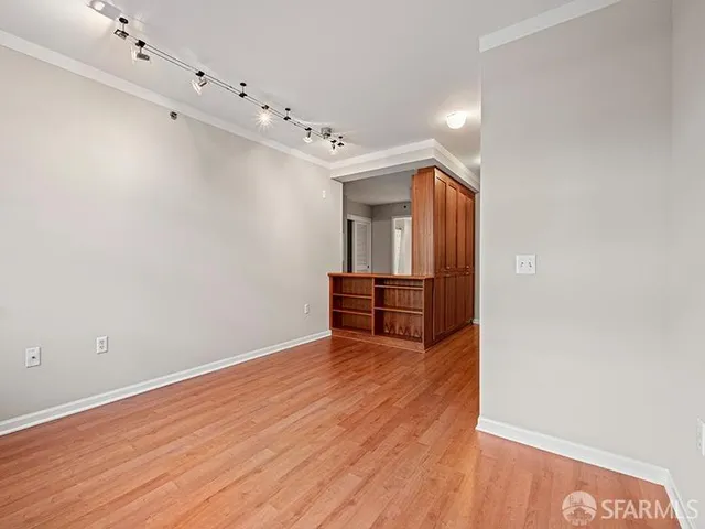 a view of an empty room with wooden floor