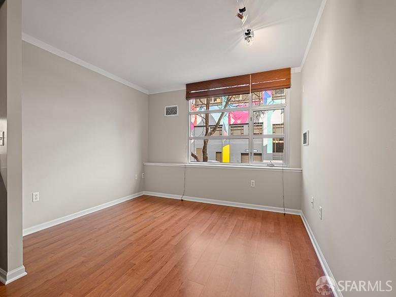 1701 Jackson Street, Unit 105 San Francisco, CA 94109 - Photo 22 of 43 an empty room with wooden floor and windows