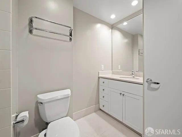 a bathroom with a toilet a sink and mirror