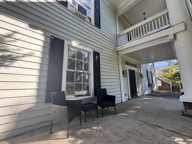 a view of a house with a patio and a yard