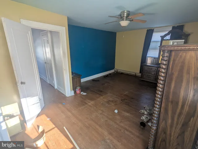 a view of empty room with wooden floor and window