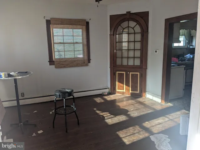 a view of an empty room with window and wooden floor