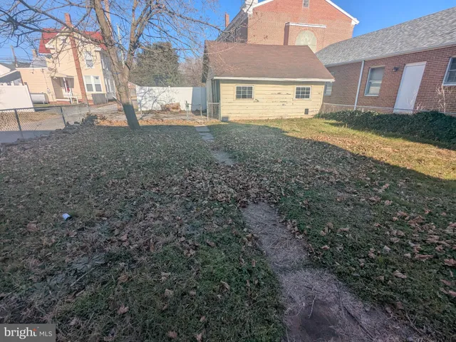 a view of a yard in front of a house with large trees