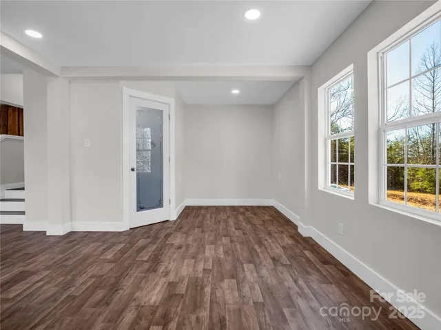 a view of a room with wooden floor and windows