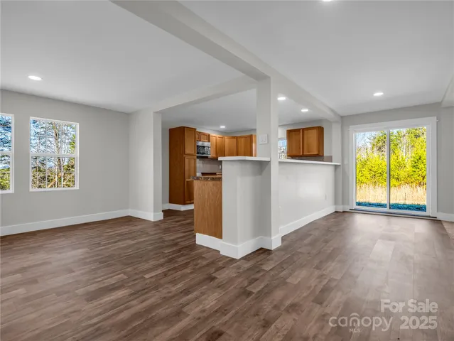 a view of a kitchen with a fridge wooden floor and windows