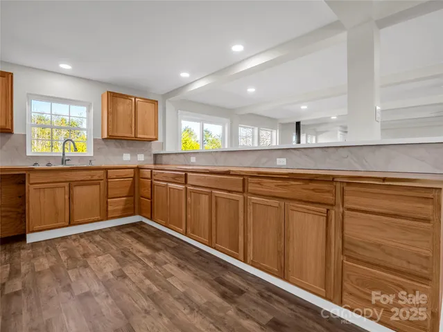 a kitchen with wooden cabinets sink and window