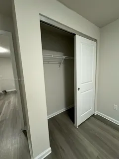 an empty room with wooden floor and closet