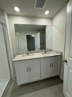 a bathroom with a double vanity sink and a mirror