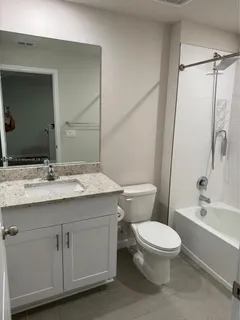 a bathroom with a granite countertop sink toilet and shower