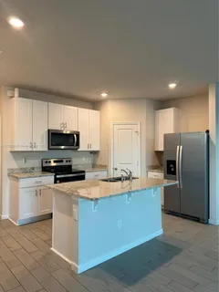a kitchen with stainless steel appliances granite countertop a stove a sink a refrigerator and a microwave