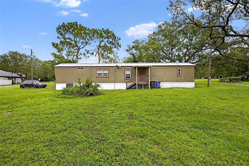 11127 McMullen Road Riverview, FL 33569 - Photo 2 of 23 a front view of a house with a yard and trees