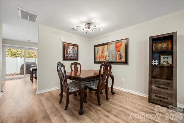 a view of a a dining room with furniture window and wooden floor