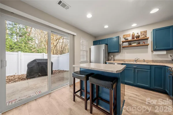 a kitchen with stainless steel appliances granite countertop a sink counter space and a refrigerator