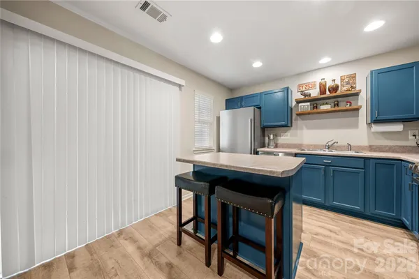 a kitchen with kitchen island a sink appliances and cabinets