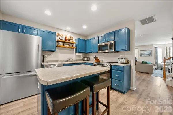 a kitchen with stainless steel appliances granite countertop a refrigerator stove microwave and sink
