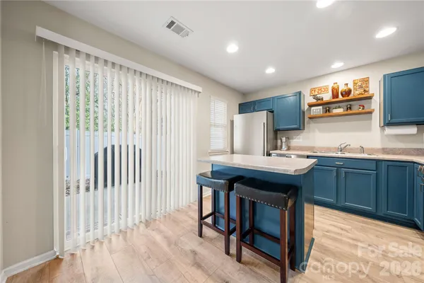a kitchen with granite countertop a sink cabinets and wooden floor