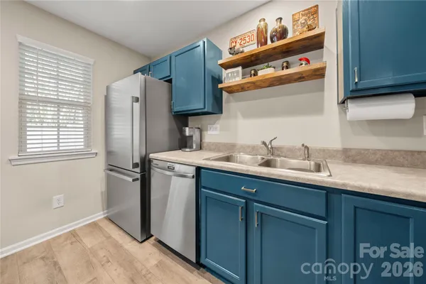 a kitchen with stainless steel appliances granite countertop a sink and a refrigerator