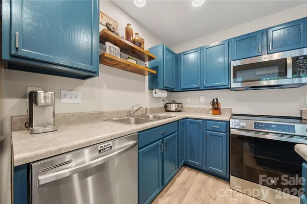 a kitchen with stainless steel appliances granite countertop a sink stove and microwave
